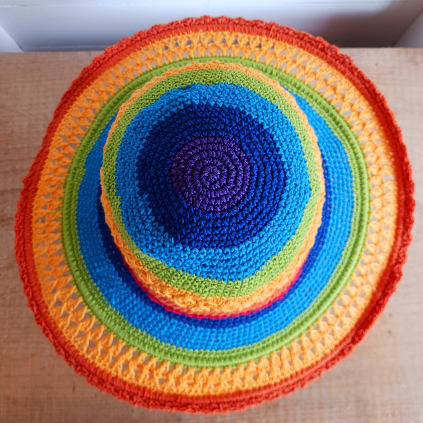 Brighten up your summer with this vibrant handmade crochet cotton sun hat! Featuring a stunning rainbow pattern, this unique hat is perfect for holidays, beach days, and festivals. A malleable wire is carefully woven into the rim, allowing you to shape the brim just how you like it. Lightweight and breathable, it's ideal for sunny adventures. Each hat is individually handcrafted, so you’ll receive the exact one pictured – a one-of-a-kind accessory to celebrate the season in style.
