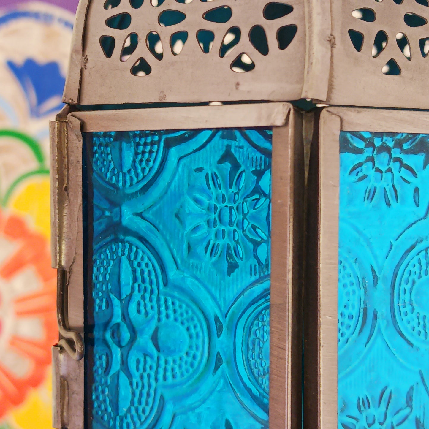 These small Moroccan style glass lanterns come in wonderful colours, featuring an intricate embossed pattern. They have a small hinged door that closes with a sliding catch. The small handle on the top is great for hanging the lanterns around your home. Perfect for adding a touch of warmth to your space.