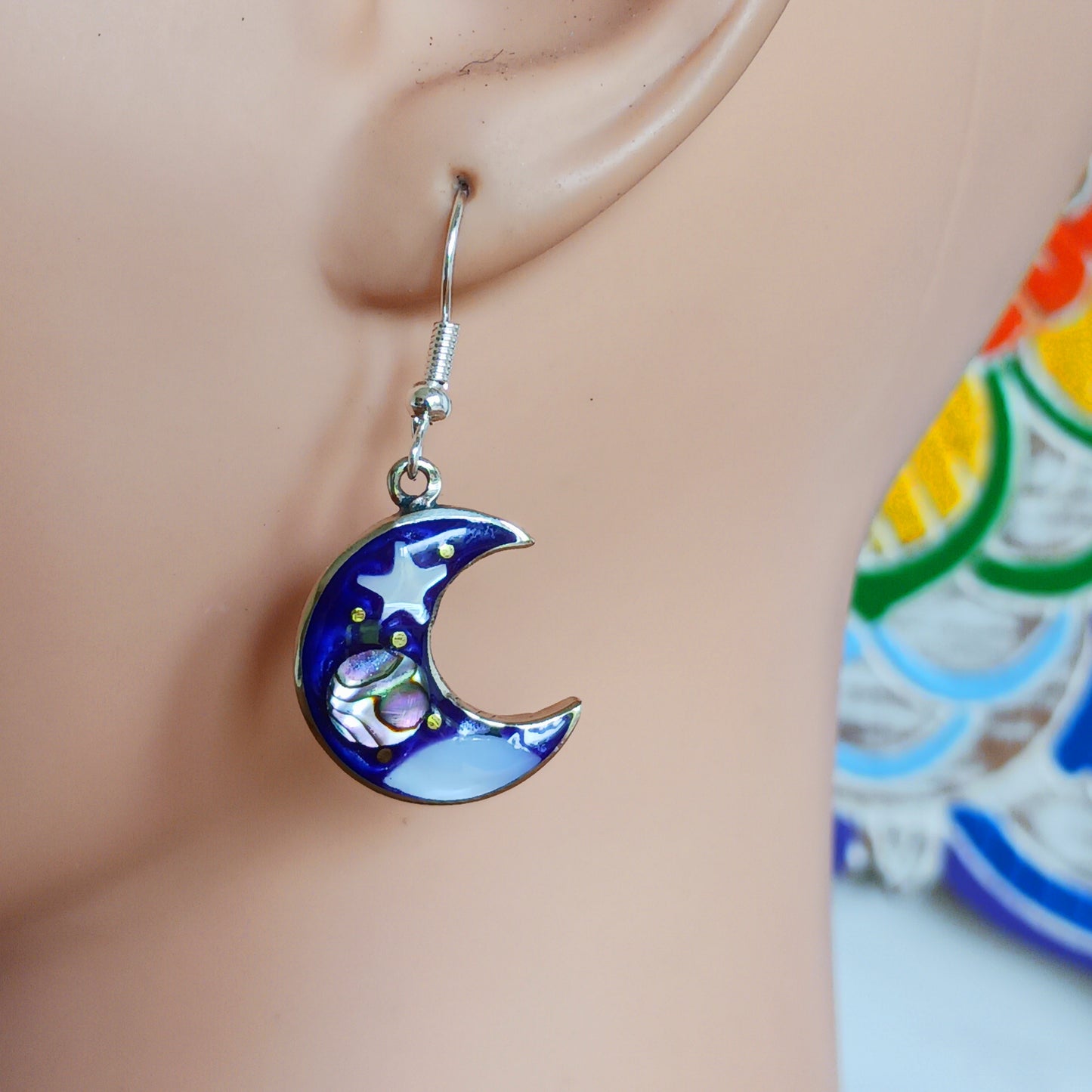 This set of beautiful celestial themed earrings are hand crafted in Taxco, Mexico. Utilising a eye-catching crescent moon design created using traditional Alpaca steel as the frame. These earrings have a celestial theme created using dyed, iridescent abalone shell.