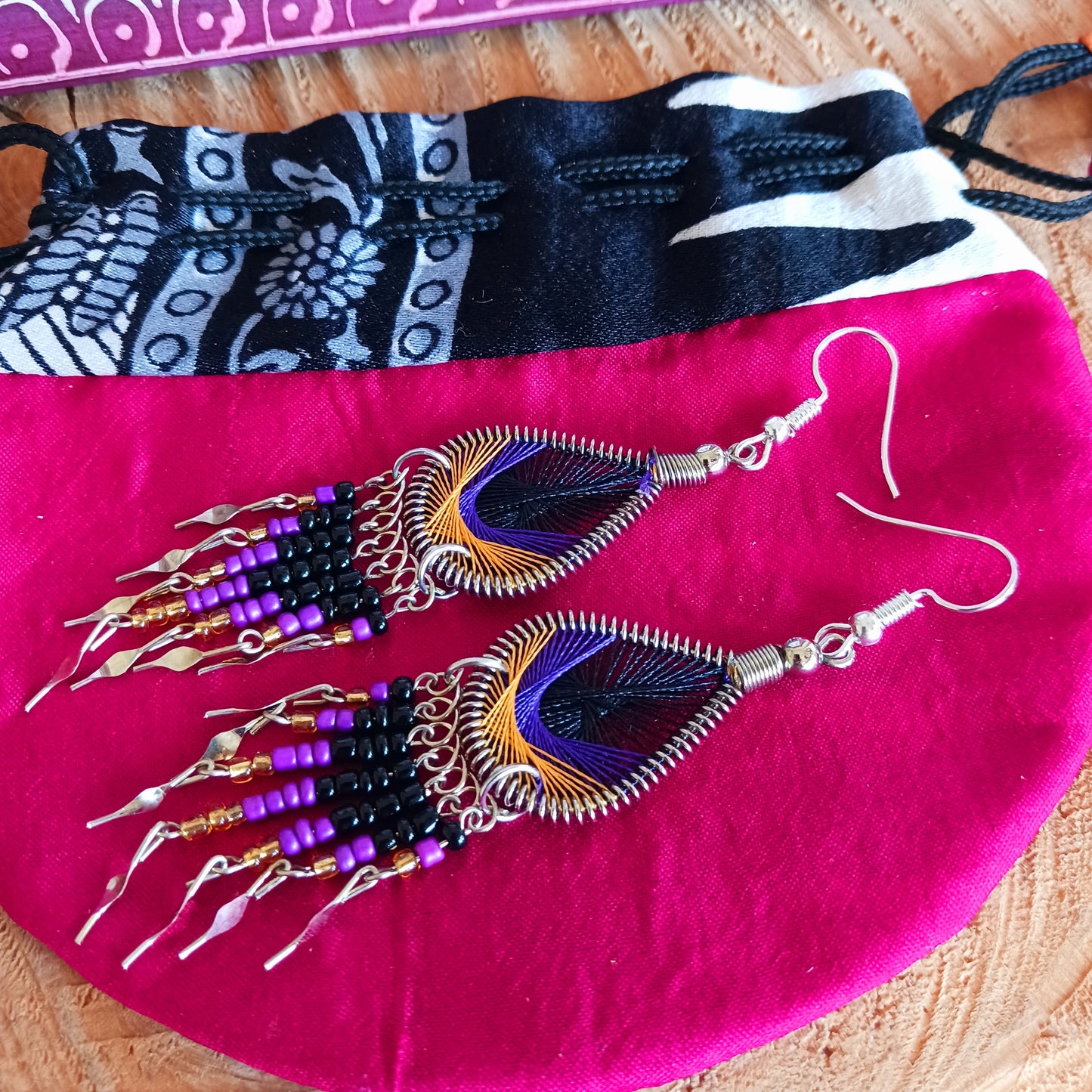These beautiful and eye-catching earrings are handmade in Peru and feature an array of gorgeous colours. A woven teardrop, similar in style to a peacock feather, is finished with co-ordinating beads and silver embellishments. Ideal for a night out or for dressing up your boho look!