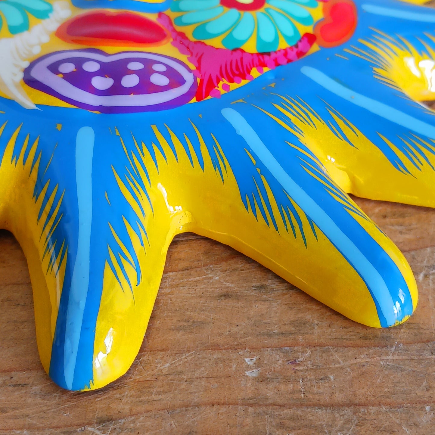 Bring a burst of colour and joy into your space with this sunny, vibrant wall plaque! Expertly hand-painted in the bold, traditional style of Xalitla, Guerrero, Mexico, this decorative piece radiates cultural charm. The vivid colors and striking glaze add depth and personality, making it a standout feature in any room. With two convenient holes for easy hanging, it’s ready to brighten your home with authentic folk art flair.
