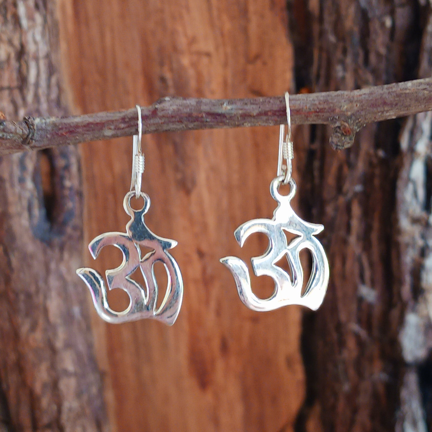 Experience spiritual harmony and elevate your style with these Sterling Silver Om dangle earrings.