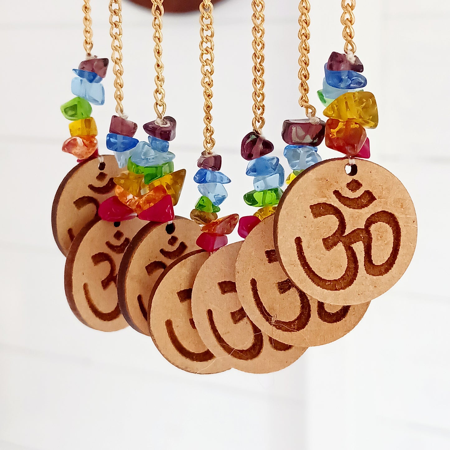 Enhance your space with spiritual harmony and vibrant energy using this beautifully crafted Wooden OHM Chakra Hanging Decoration. Featuring a finely engraved wooden OHM symbol and seven dangling OHM charms, each representing one of the seven chakra colors, this unique piece blends powerful symbolism with elegant design.