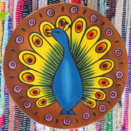 This lovely handmade, carved and painted stool is Fairtrade from Thailand. The top of this stool has been carefully hand carved and then painted to show a radiantly beautiful peacock, displaying his wonderful plumage. These cheeky little items are very versatile making great stools for little bums or as tiny tables to add accent to your home.