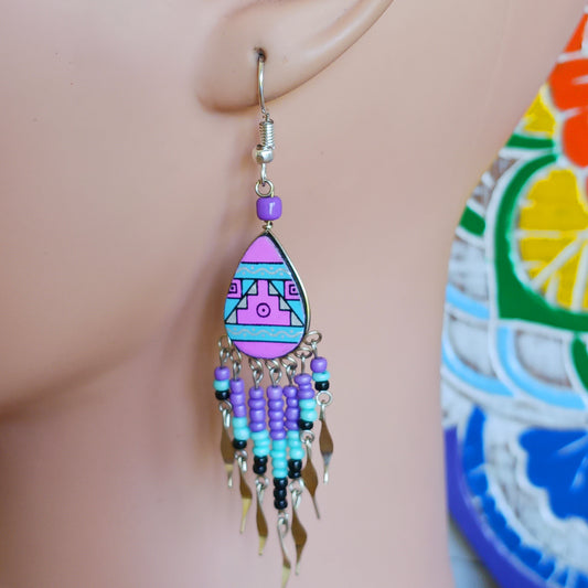 These beautiful and eye-catching earrings are handmade in Peru and feature traditional Incan patterns on the front, the back is coloured black. They are shaped in a teardrop style and are finished with coloured coordinating beads, silver embellishments and silver-plated hooks.