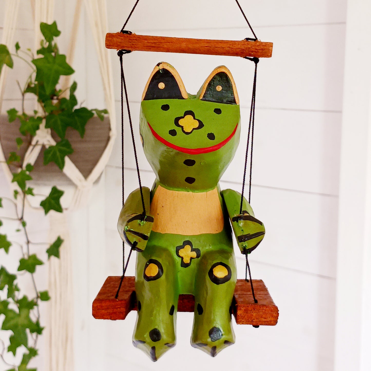 Add charm and whimsy to any space with this adorable hand-carved wooden frog! Perched on a swing and suspended by a long spring, this frog bounces gently in the air, bringing playful motion and joy to any room. Each piece is carefully hand-painted and carved from fast-growing, sustainably harvested albesia wood, making it a more eco-friendly choice for softwood décor. Whether for a nursery, porch, or creative space, this eye-catching novelty is sure to delight kids and adults alike!