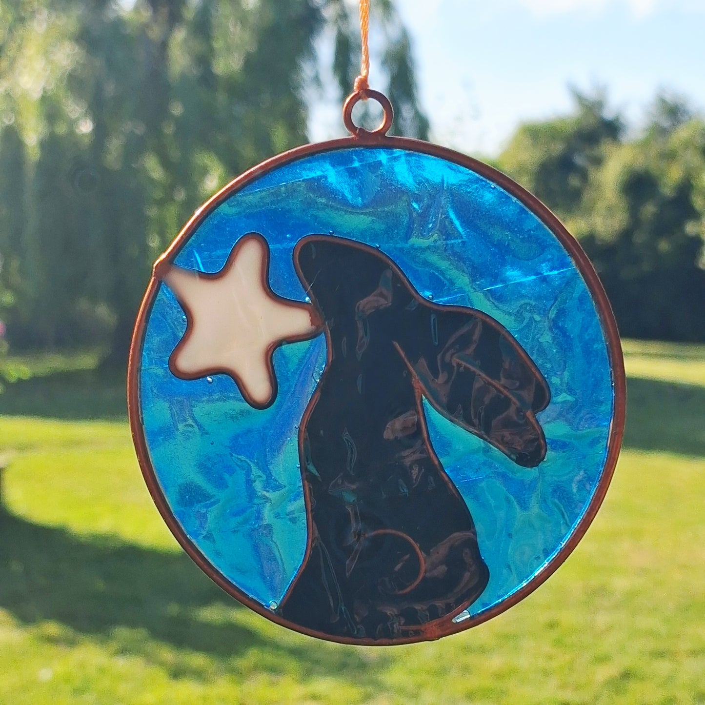 Invite the mystical energy of nature into the home with this little pagan suncatcher featuring a moon gazing hare and moon design. Handcrafted in Bali, this enchanting piece is sure to infuse any space with a touch of earthly charm.