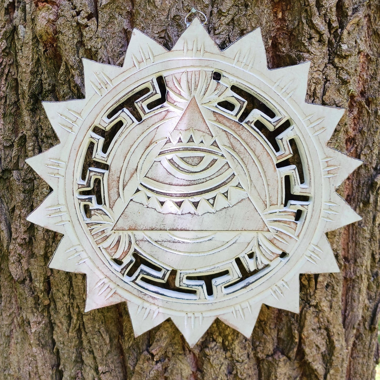 This wooden plaque has been intricately carved by hand to represent the Eye of Providence. The Eye of Providence or All-Seeing Eye is a symbol depicting an eye, often enclosed in a triangle and surrounded by a ray of light or a halo, intended to represent Providence, as the eye watches over the workers of mankind. In Christianity it serves as a reminder that humanitiy's thoughts and deeds are always obserbed by God.