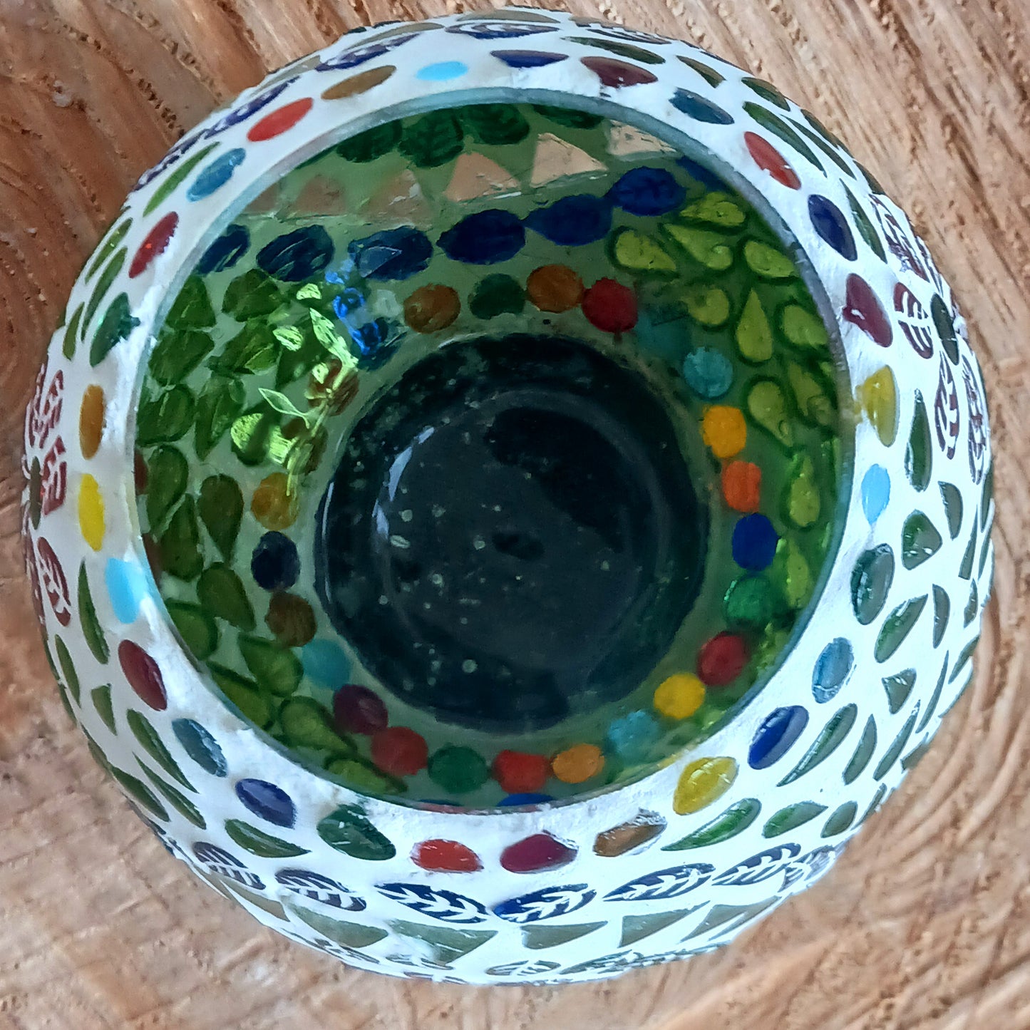 These beautiful tealight holders are a mosaic mixture of pearlescent and block colours that create a vibrant floral mandala design on this glass tealight holder. Pop in a lit tealight to warm the atmosphere with multi colour vibes on outdoor summer evenings, or indoors to brighten the long dark evenings.