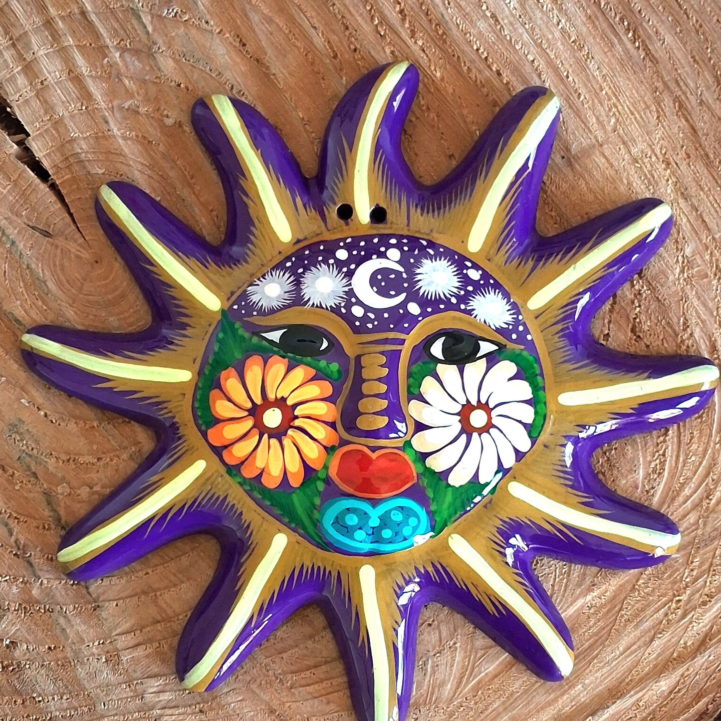 This sunny and vibrant wall plaque will get you smiling! It has been beautifully hand painted in a bright style traditional to Xalitla, a region of Guerrero, Mexico. A striking glaze adds to the bold design. It has two holes which can be used to add a hanging loop for an easy display.
