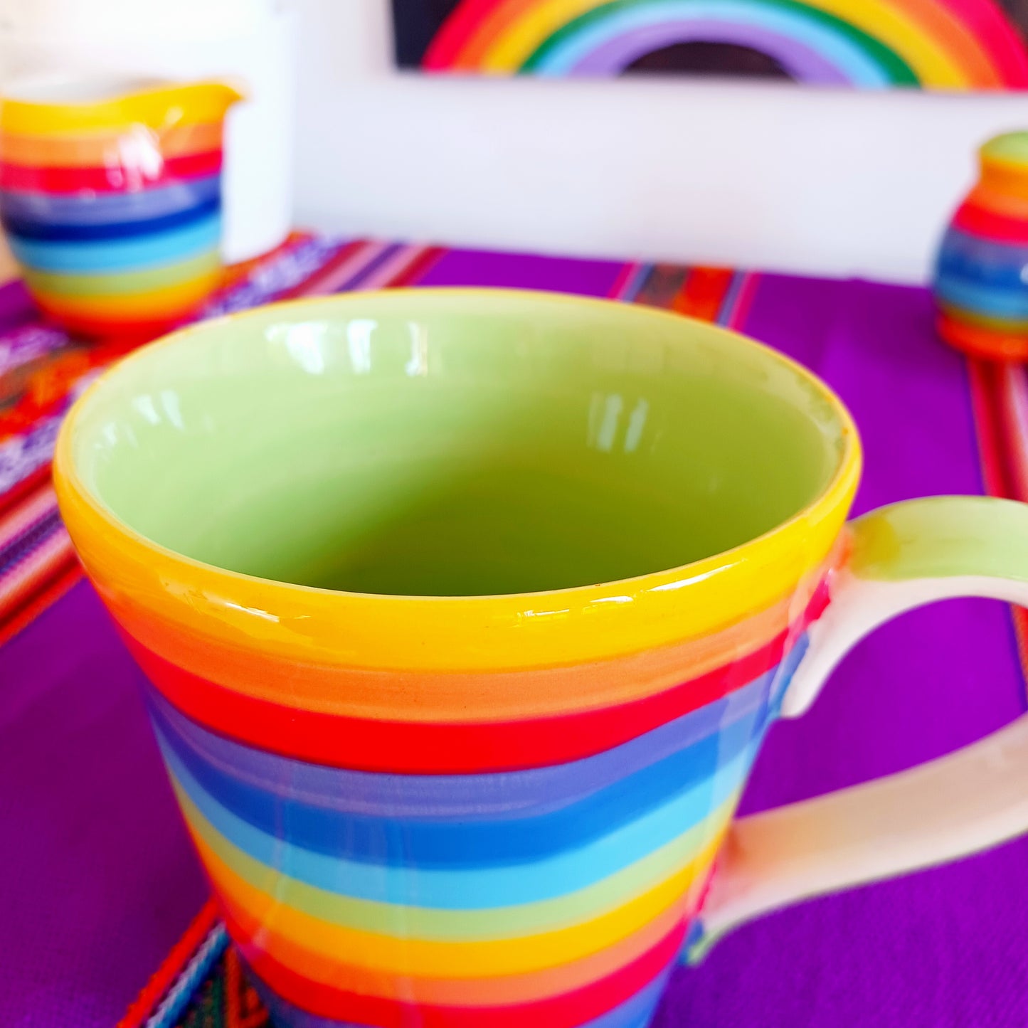 The rainbow stripe is hand painted before it is fired and finishes it beautifully. Narrower in diameter at the bottom and widening towards the rim, these Thai ceramics are traditionally made, hand painted with a pale green interior and finished to a shine glaze highlighting the vibrant multi colours perfectly.