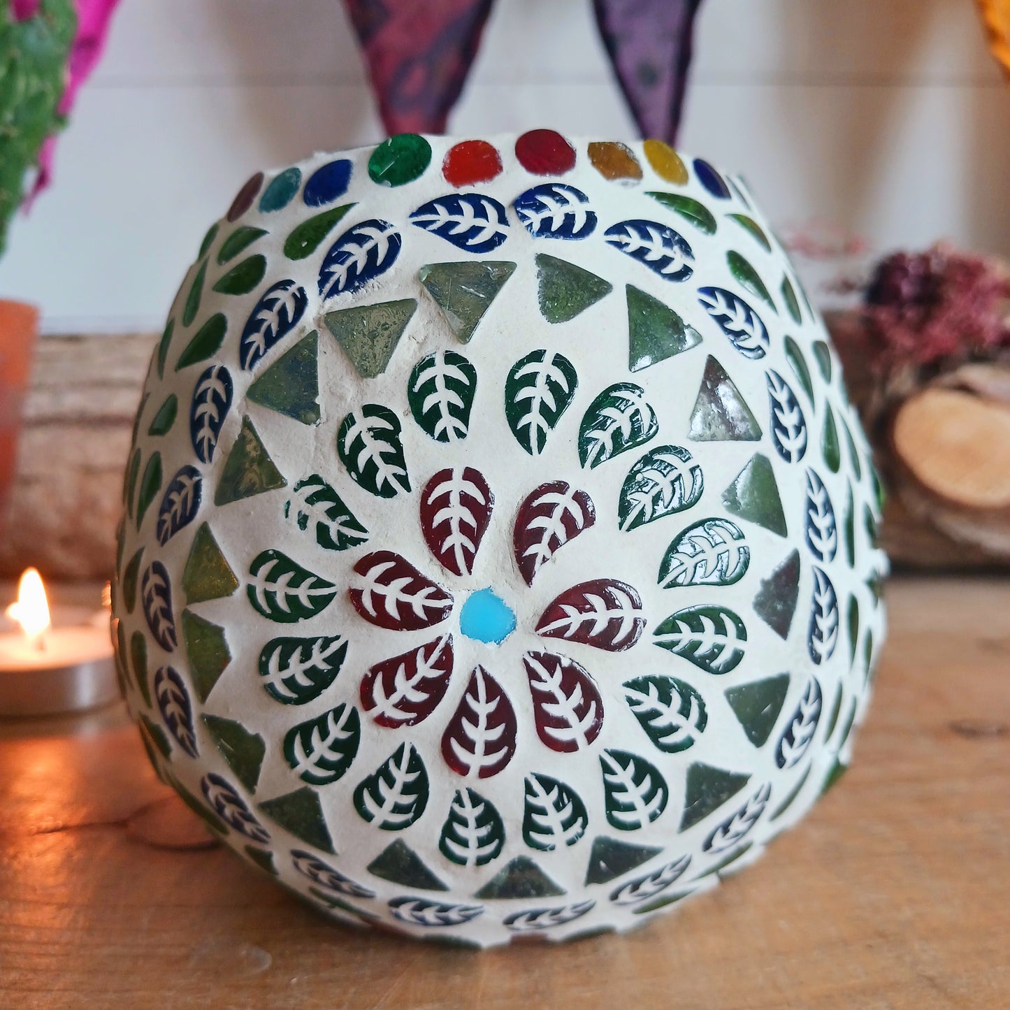 These beautiful tealight holders are a mosaic mixture of pearlescent and block colours that create a vibrant floral mandala design on this glass tealight holder. Pop in a lit tealight to warm the atmosphere with multi colour vibes on outdoor summer evenings, or indoors to brighten the long dark evenings.