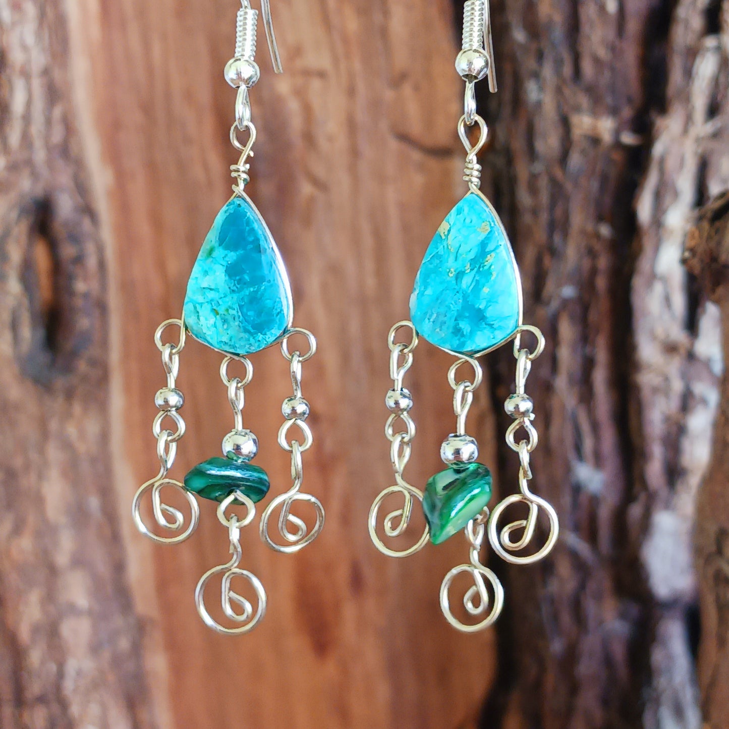 These beautiful spiral earrings feature a turquoise stone and three spirals. They dangle really nicely when worn, and are easy to dress up or down. The hooks are made from sterling silver.