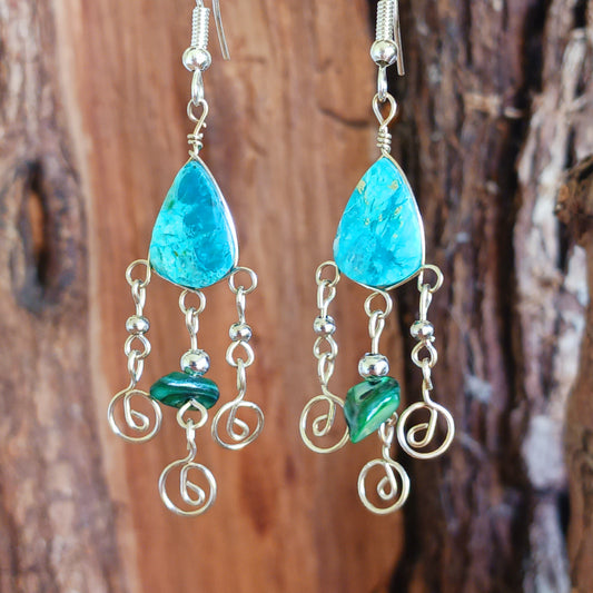 These beautiful spiral earrings feature a turquoise stone and three spirals. They dangle really nicely when worn, and are easy to dress up or down. The hooks are made from sterling silver.