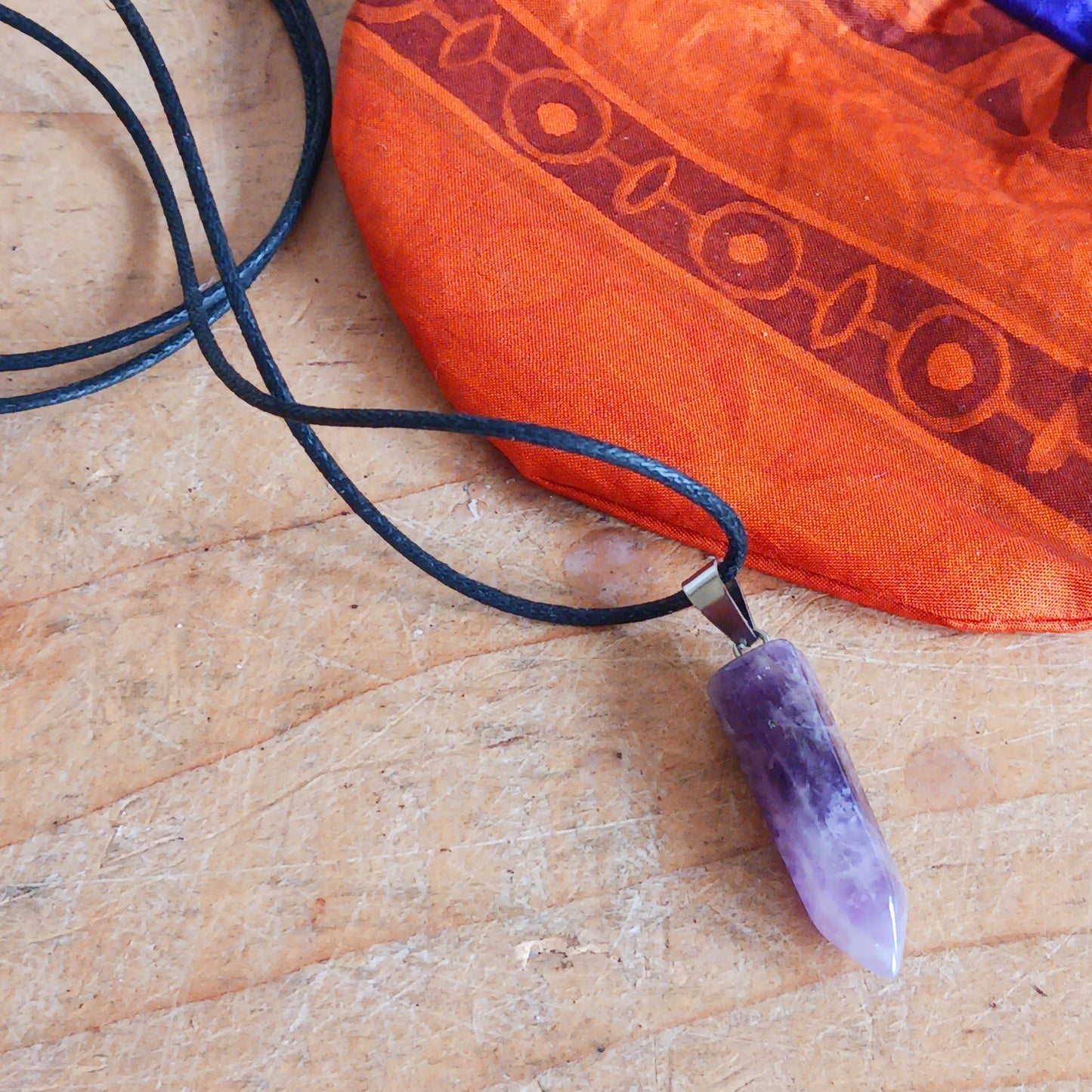 Elevate your style and energy with this stunning Amethyst Crystal Pendant Necklace. Featuring a natural amethyst crystal on a sleek black cord, this piece is both a beautiful accessory and a powerful spiritual tool. Amethyst, known as the stone of spirituality and peace, ranges in shades from soft lavender to deep violet.