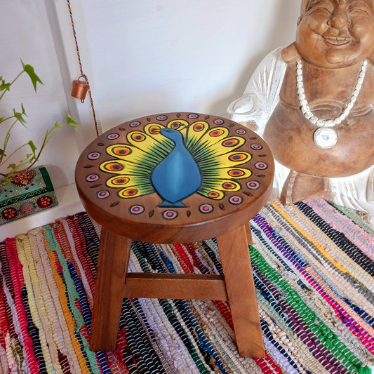 This lovely handmade, carved and painted stool is Fairtrade from Thailand. The top of this stool has been carefully hand carved and then painted to show a radiantly beautiful peacock, displaying his wonderful plumage. These cheeky little items are very versatile making great stools for little bums or as tiny tables to add accent to your home.