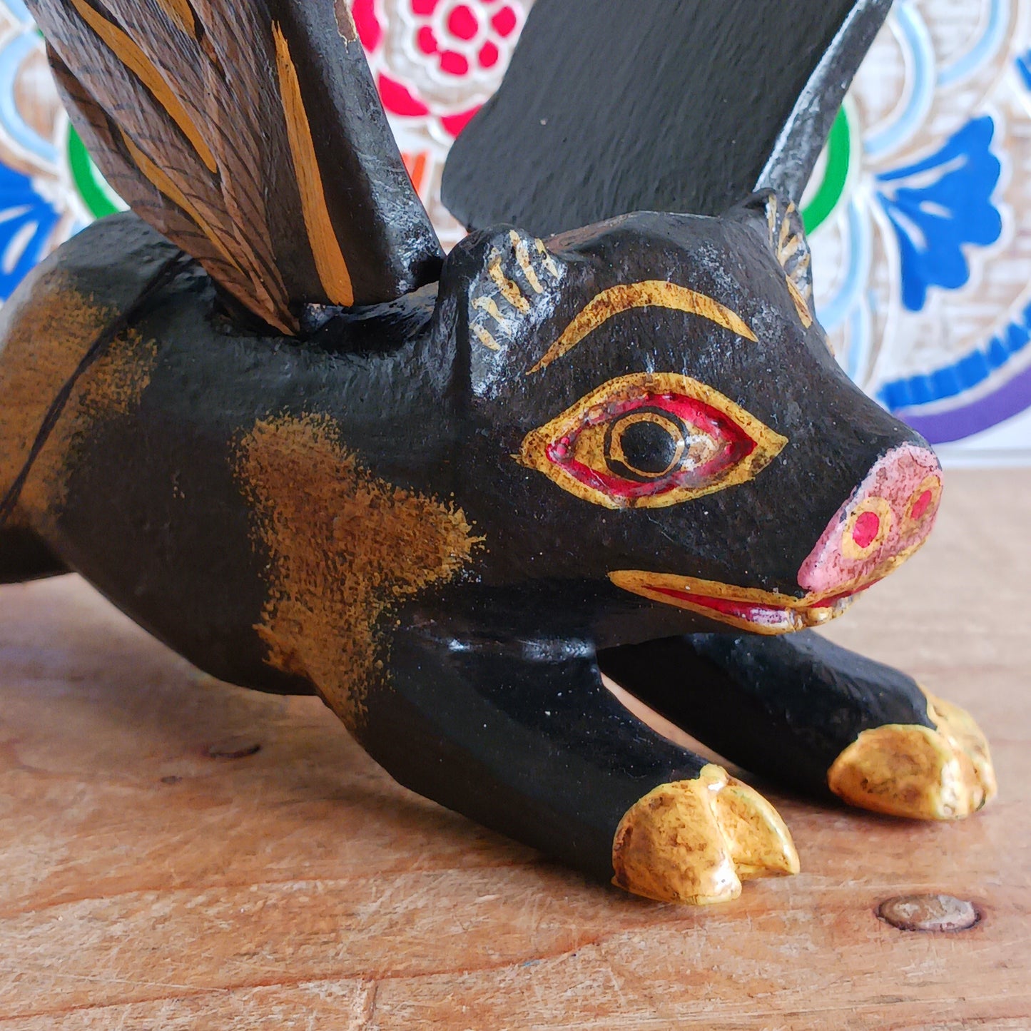 Invite protective energy and traditional charm into your home with this handcrafted Flying Pig Spirit Guardian from Bali. Known locally as a "Cradle Guardian," this winged figure is believed to ward off negative entities and is often placed in temples or homes, suspended from elevated areas like doorways or windows. Its downward-facing posture channels protection, while the strong twine loop allows for easy hanging.