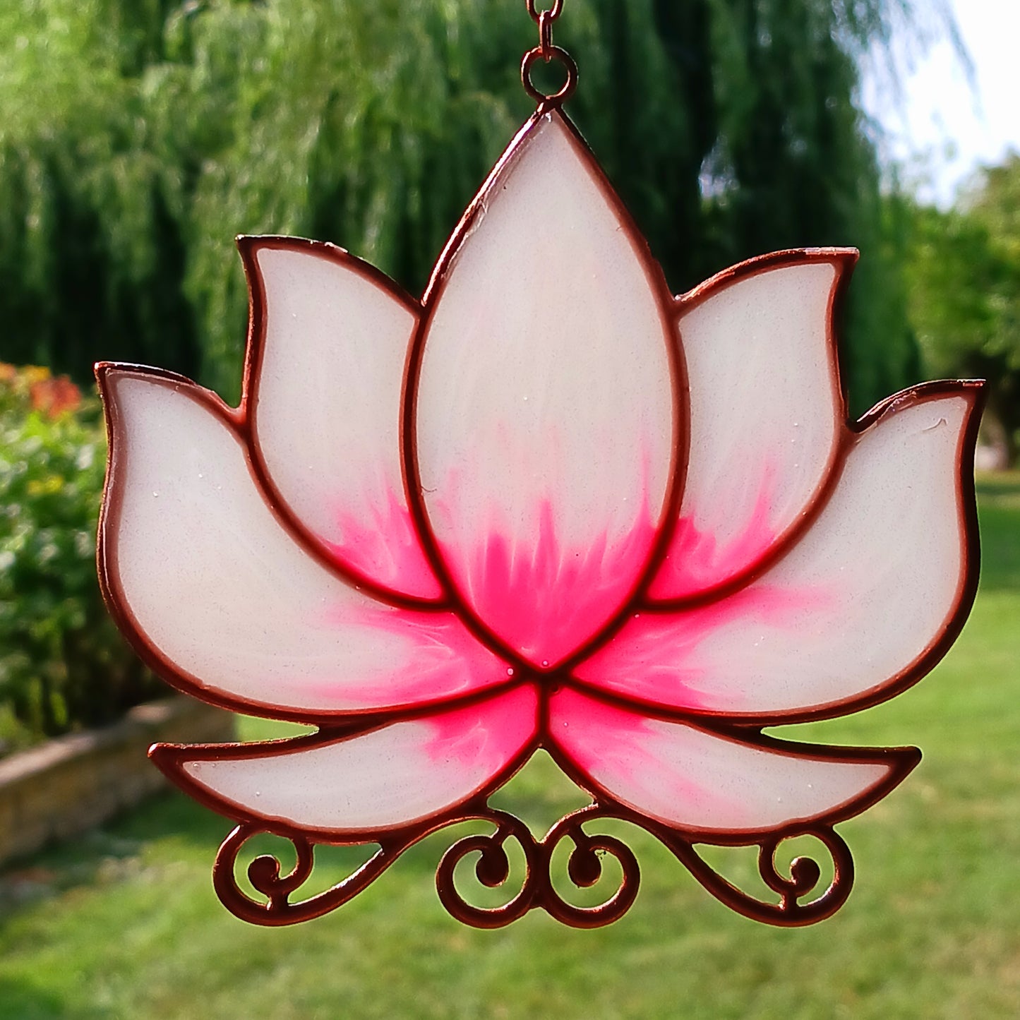 Bring a touch of tranquility to your space with this beautifully crafted lotus flower window hanger. Made from vibrant coloured glass and outlined in sleek metal framing, this piece combines simplicity and elegance. When sunlight passes through, it creates a radiant, uplifting display of color. Hang it in any window to inspire peace, mindfulness, and beauty in your home or workspace.