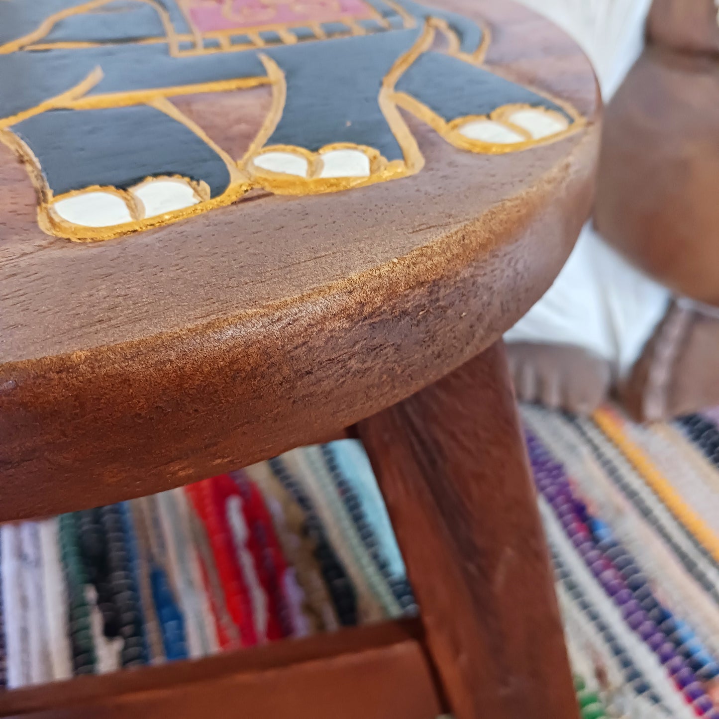 This sturdy little foot stool is from northern Thailand and features a lovely hand carved image of a festival elephant with gold paint detail. The stool is made from sustainable acacia wood. It is strong enough to sit on, use as a plant stand or purely for decoration.