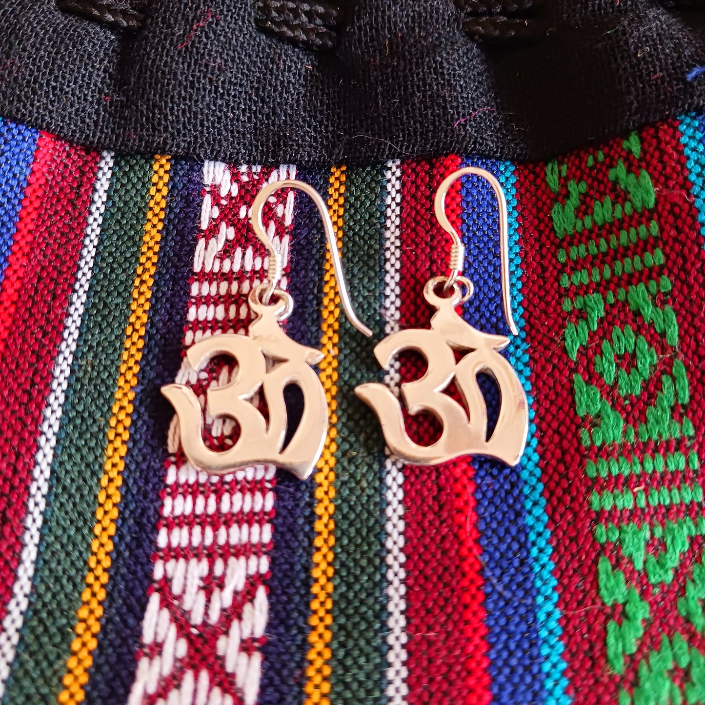 Experience spiritual harmony and elevate your style with these Sterling Silver Om dangle earrings.