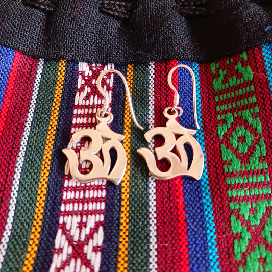 Experience spiritual harmony and elevate your style with these Sterling Silver Om dangle earrings.