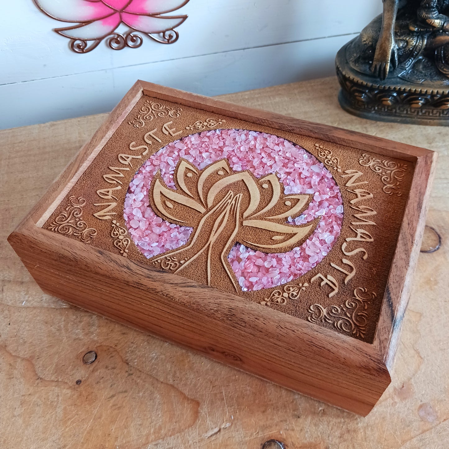 Keep your cherished items safe in this beautifully crafted mango wood jewellery box, engraved with the word ‘Namaste’. A Sanskrit greeting meaning “the divine in me greets the divine in you,” it serves as a daily reminder of connection, presence, and mutual respect. Accented with rose quartz—symbolizing love, compassion, and emotional healing—this box is ideal for storing jewellery, keepsakes, cards, or other personal treasures. Subtle, spiritual, and thoughtful, it’s a meaningful addition to any space.