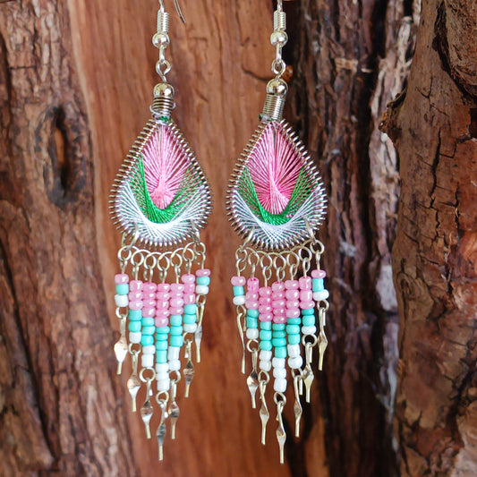 These beautiful and eye-catching earrings are handmade in Peru and feature an array of gorgeous colours. A woven teardrop, similar in style to a peacock feather, is finished with co-ordinating beads and silver embellishments. Ideal for a night out or for dressing up your boho look!