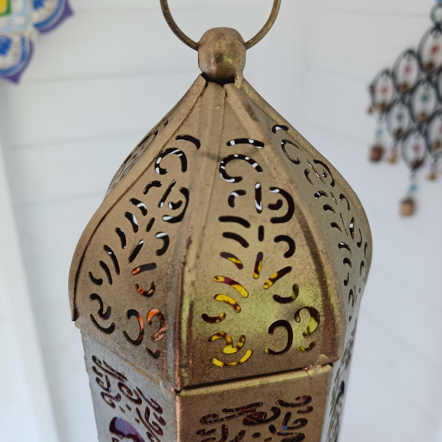 Discover the enchanting seven-sided standing lantern, each side beautifully illustrating one of the unique chakra symbols. Crafted from exquisite gold metal, this lantern not only adds a touch of elegance to any space but also features a convenient bottom turn-opening door that doubles as a candle holder tray.