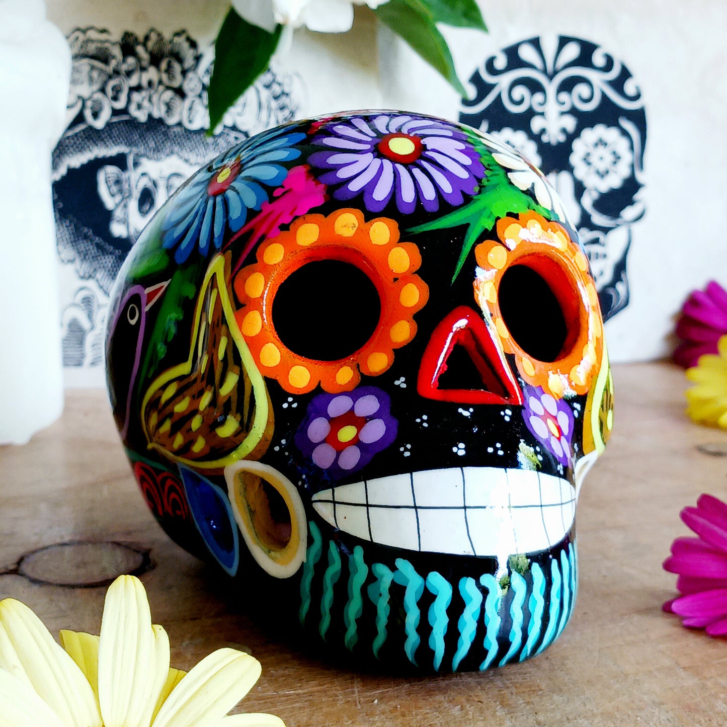These fun ceramic sugar skull ornaments have been beautifully painted in bright colours and finished with a high shine glaze. They are a popular item during Día de Los Muertos or Day of the Dead festivities, held in Mexico every November to celebrate welcoming the souls of their deceased relatives back for a time of food, drink and celebration.