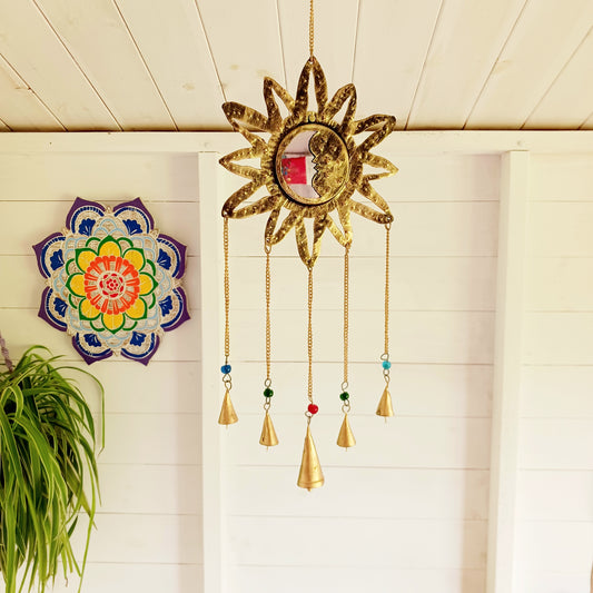 Introduce a radiant touch to any space in your home or garden with this sun and moon Indian chime featuring a small mirror and five delicate bells. The brass sun and moon design symbolizes harmony between opposing forces - light and darkness, day and night. A small reflective mirror at the centre enhances the aesthetic while adding a touch of mysticism. The five hanging bells, accented with colourful beads, offer a gentle chime, creating a soothing atmosphere whether indoors or outdoors.