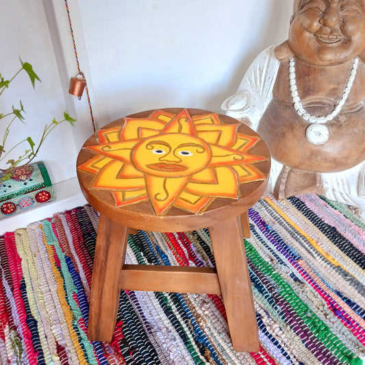 This lovely little handmade, carved and painted stool is Fairtrade from Thailand. It features a vibrant, radiant sun carving with beautiful gold detailing. These cheeky little items are very versatile making great stools for little bums or as tiny tables to add accent to your home. They can also be very useful as a step for those hard to reach high up shelves or even just to put your feet up on, and due to their small form are easy to store.