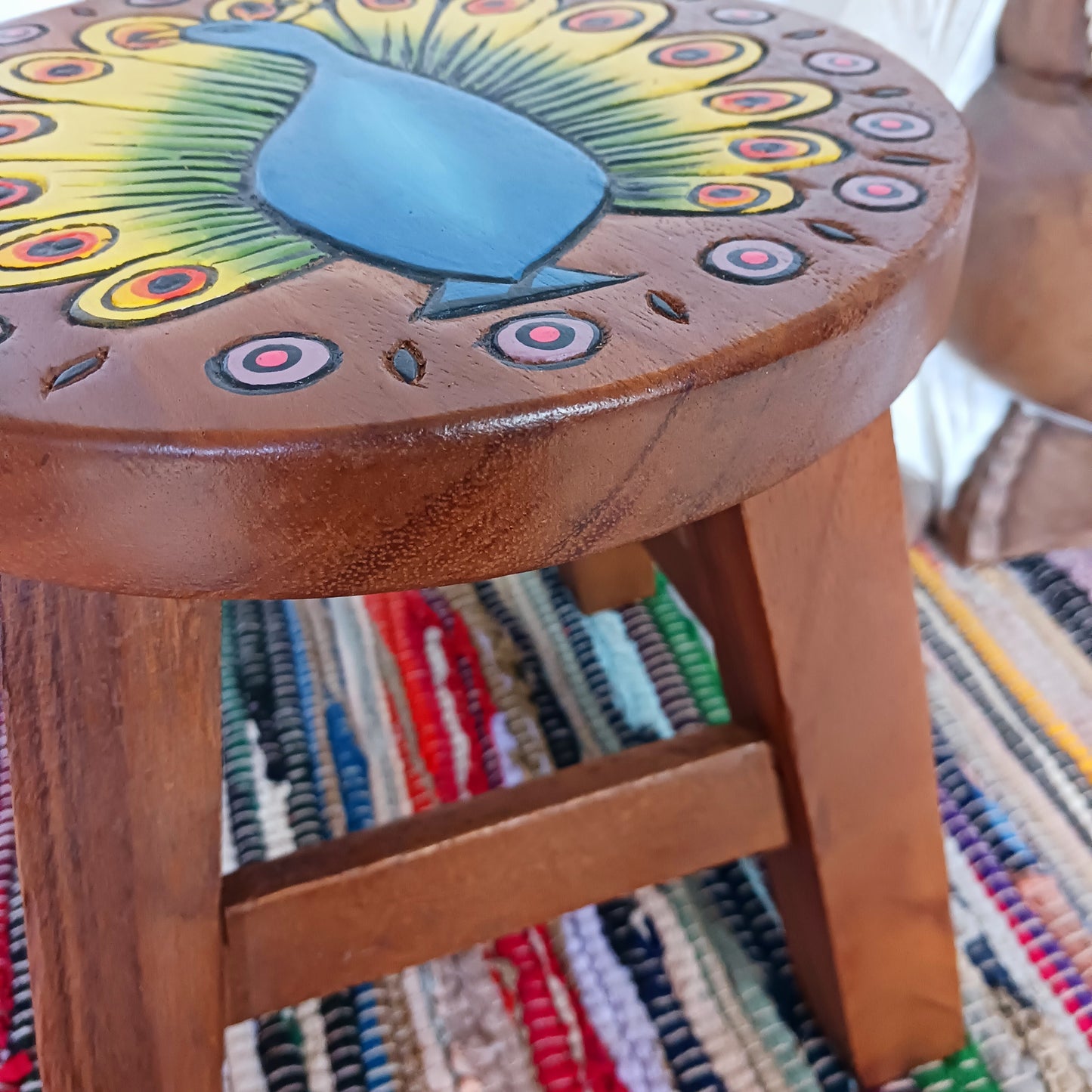 This lovely handmade, carved and painted stool is Fairtrade from Thailand. The top of this stool has been carefully hand carved and then painted to show a radiantly beautiful peacock, displaying his wonderful plumage. These cheeky little items are very versatile making great stools for little bums or as tiny tables to add accent to your home.