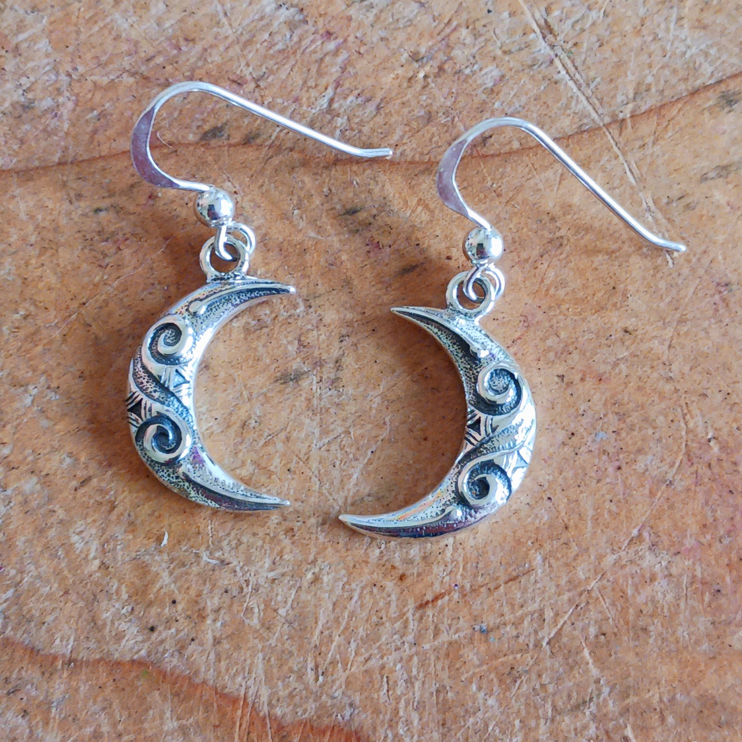 These exquisite sterling silver earrings feature a delicate Celtic spiral design beautifully interwoven in the crescent moon shape, symbolizing the waxing and waning phases. Crafted with fine attention to detail, each earring mirrors the other, representing balance in nature and the eternal cycles of life, growth, and renewal.