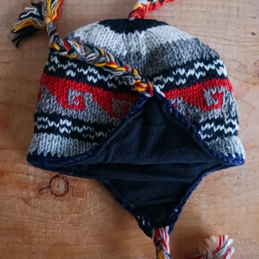 Stay cozy and stylish with our handmade chunky wool earflap hats, crafted in Nepal by skilled women artisans in Kathmandu. Each hat is 100% pure wool and features a soft polar fleece lining for extra warmth and comfort. Perfect for cold winter days, outdoor adventures, or adding a touch of handmade charm to your look.