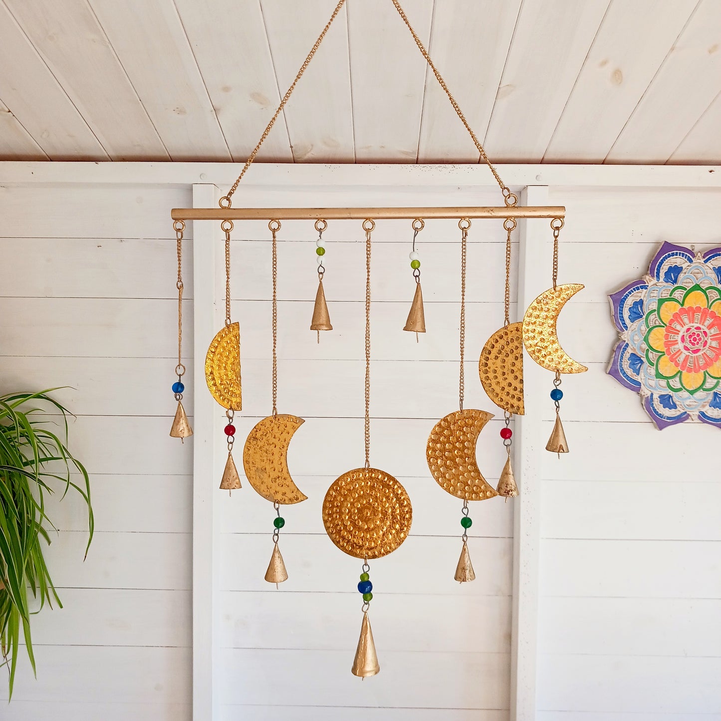 Add a little celestial beauty to your home with this unique brass Moon Phases Chimes. Made in India, it showcases the phases of the moon in stunningbrass, making it a striking piece for any space. Featuring intricate designs of each lunar phase, symbolizing the cycle of life and renewal.