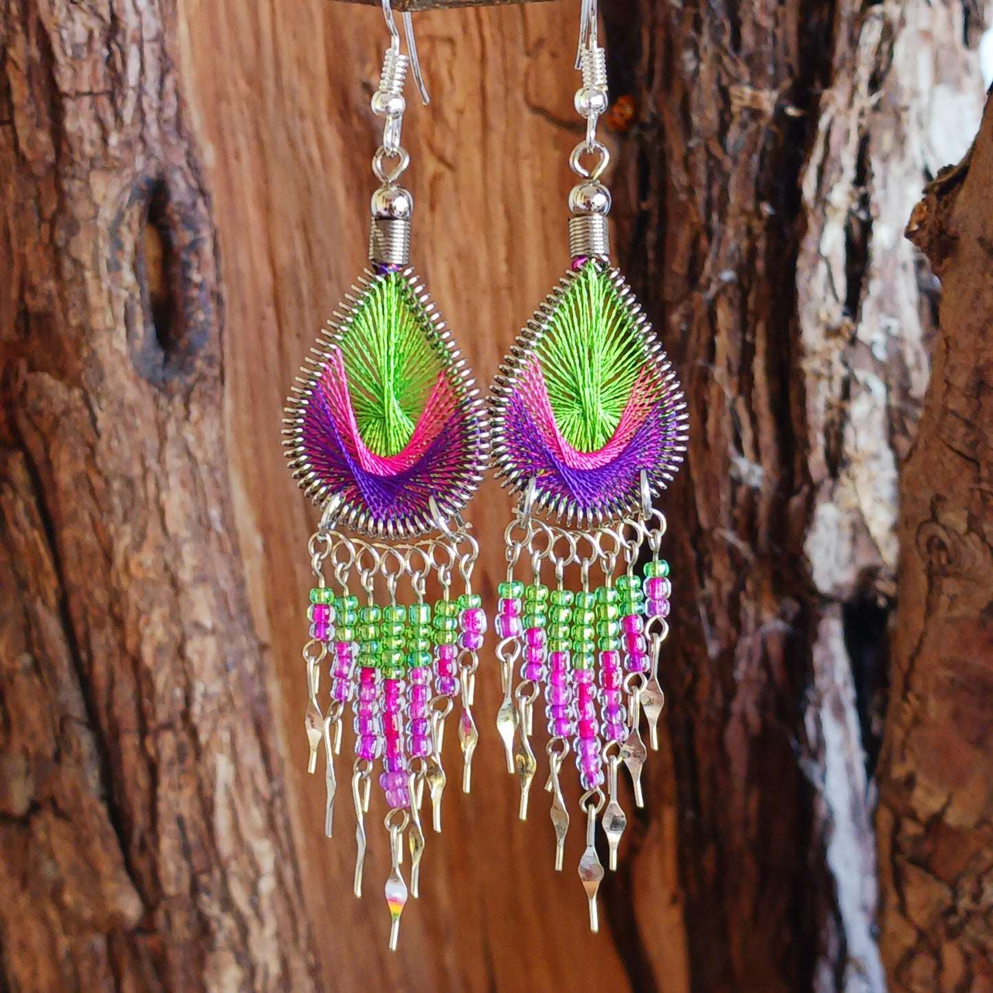 These beautiful and eye-catching earrings are handmade in Peru and feature an array of gorgeous colours. A woven teardrop, similar in style to a peacock feather, is finished with co-ordinating beads and silver embellishments. Ideal for a night out or for dressing up your boho look!