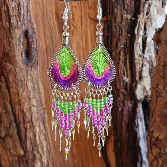 These beautiful and eye-catching earrings are handmade in Peru and feature an array of gorgeous colours. A woven teardrop, similar in style to a peacock feather, is finished with co-ordinating beads and silver embellishments. Ideal for a night out or for dressing up your boho look!