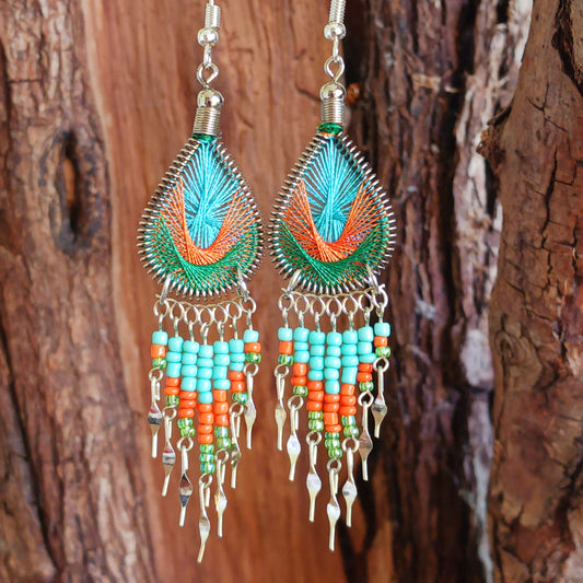 These beautiful and eye-catching earrings are handmade in Peru and feature an array of gorgeous colours. A woven teardrop, similar in style to a peacock feather, is finished with co-ordinating beads and silver embellishments. Ideal for a night out or for dressing up your boho look!