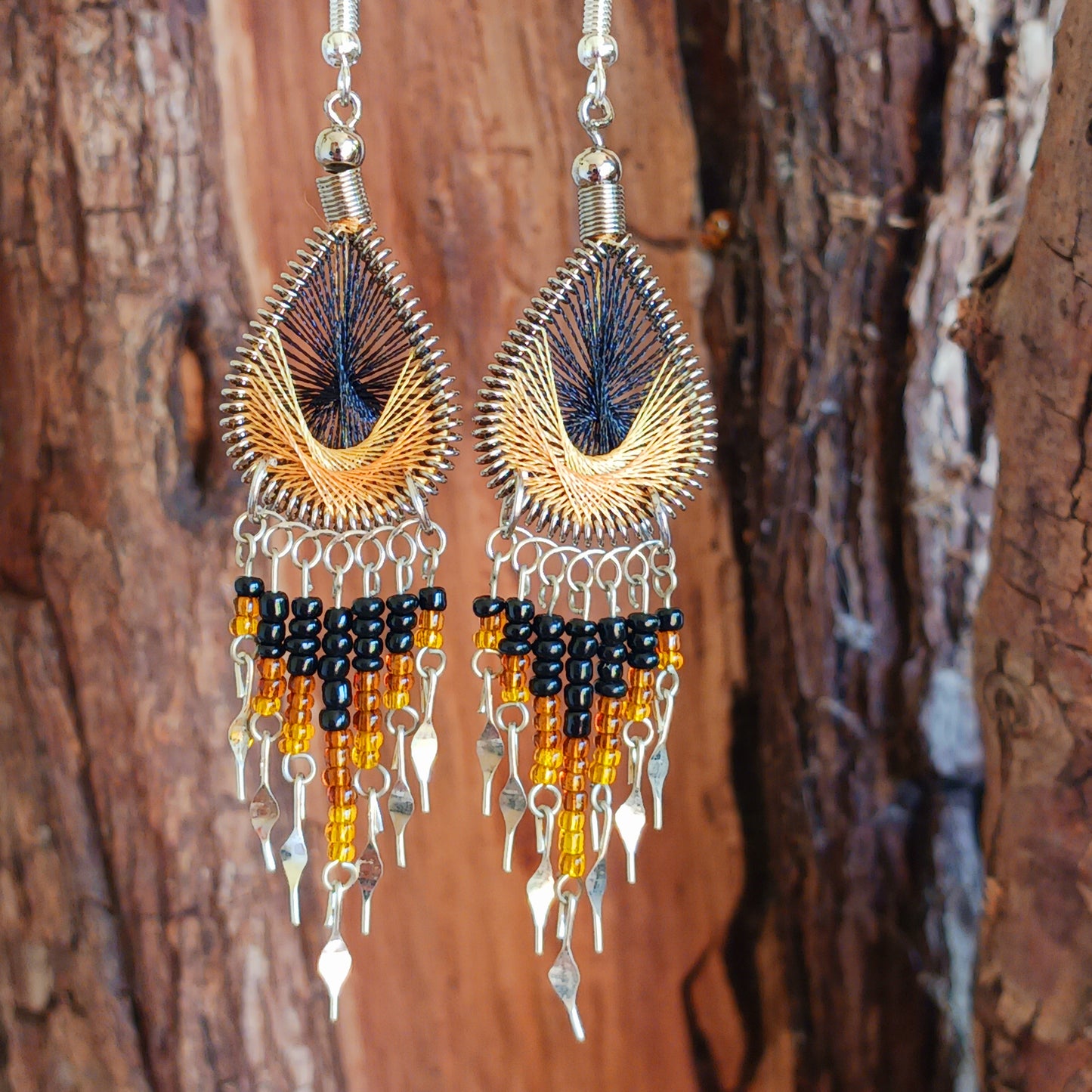 These beautiful and eye-catching earrings are handmade in Peru and feature an array of gorgeous colours. A woven teardrop, similar in style to a peacock feather, is finished with co-ordinating beads and silver embellishments. Ideal for a night out or for dressing up your boho look!