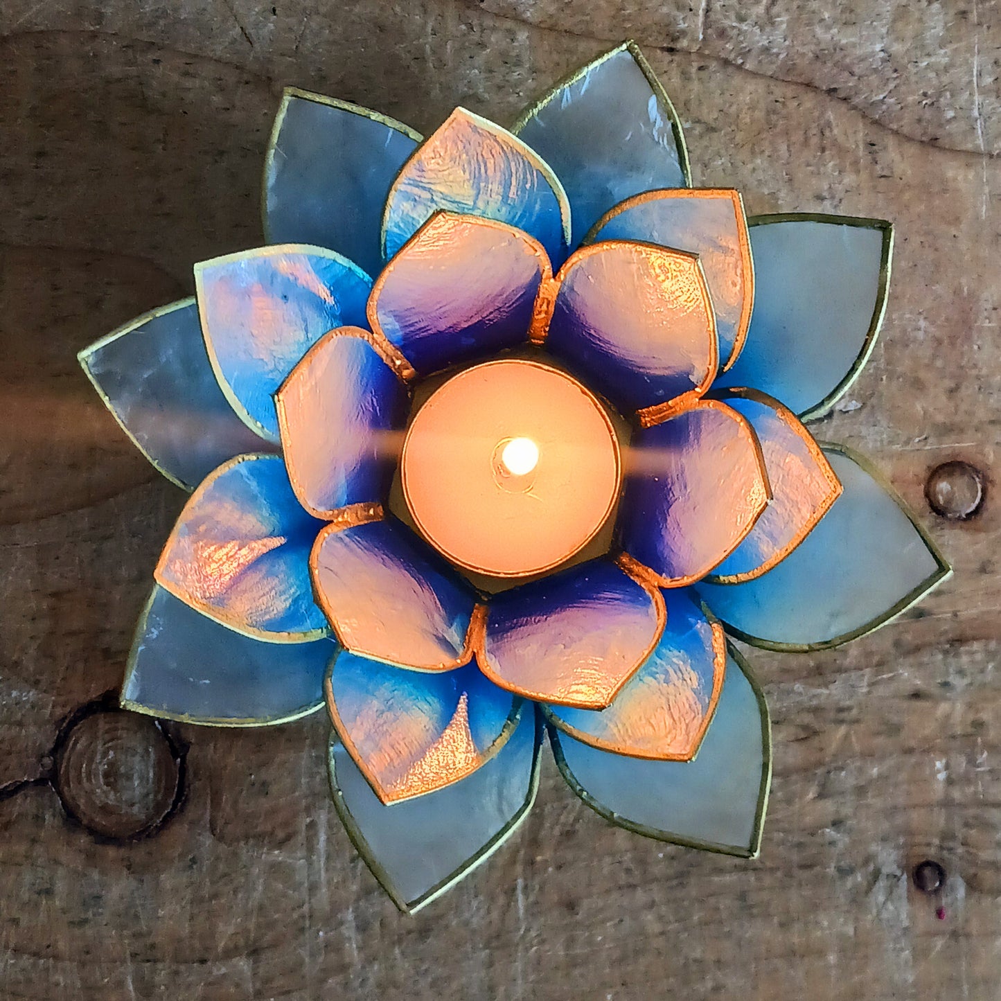 Illuminate your space with the peaceful elegance of our Capiz Shell Lotus Flower Candle Holder. Symbolizing enlightenment and serenity, this stunning handcrafted piece features delicate blue and white petals edged in silver, forming the iconic lotus shape. When lit, the layered design diffuses candlelight into a soft, radiant glow — ideal for creating a calming ambiance indoors or outdoors.