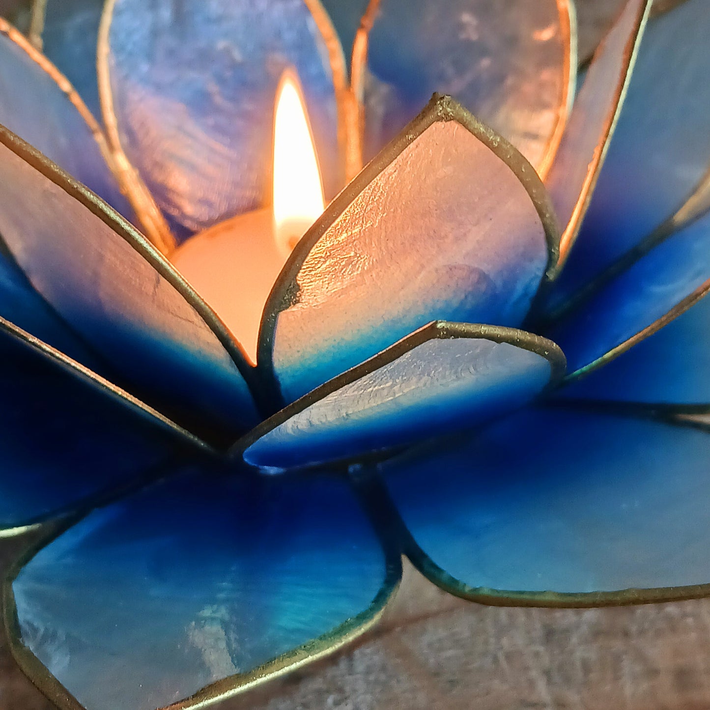 Illuminate your space with the peaceful elegance of our Capiz Shell Lotus Flower Candle Holder. Symbolizing enlightenment and serenity, this stunning handcrafted piece features delicate blue and white petals edged in silver, forming the iconic lotus shape. When lit, the layered design diffuses candlelight into a soft, radiant glow — ideal for creating a calming ambiance indoors or outdoors.