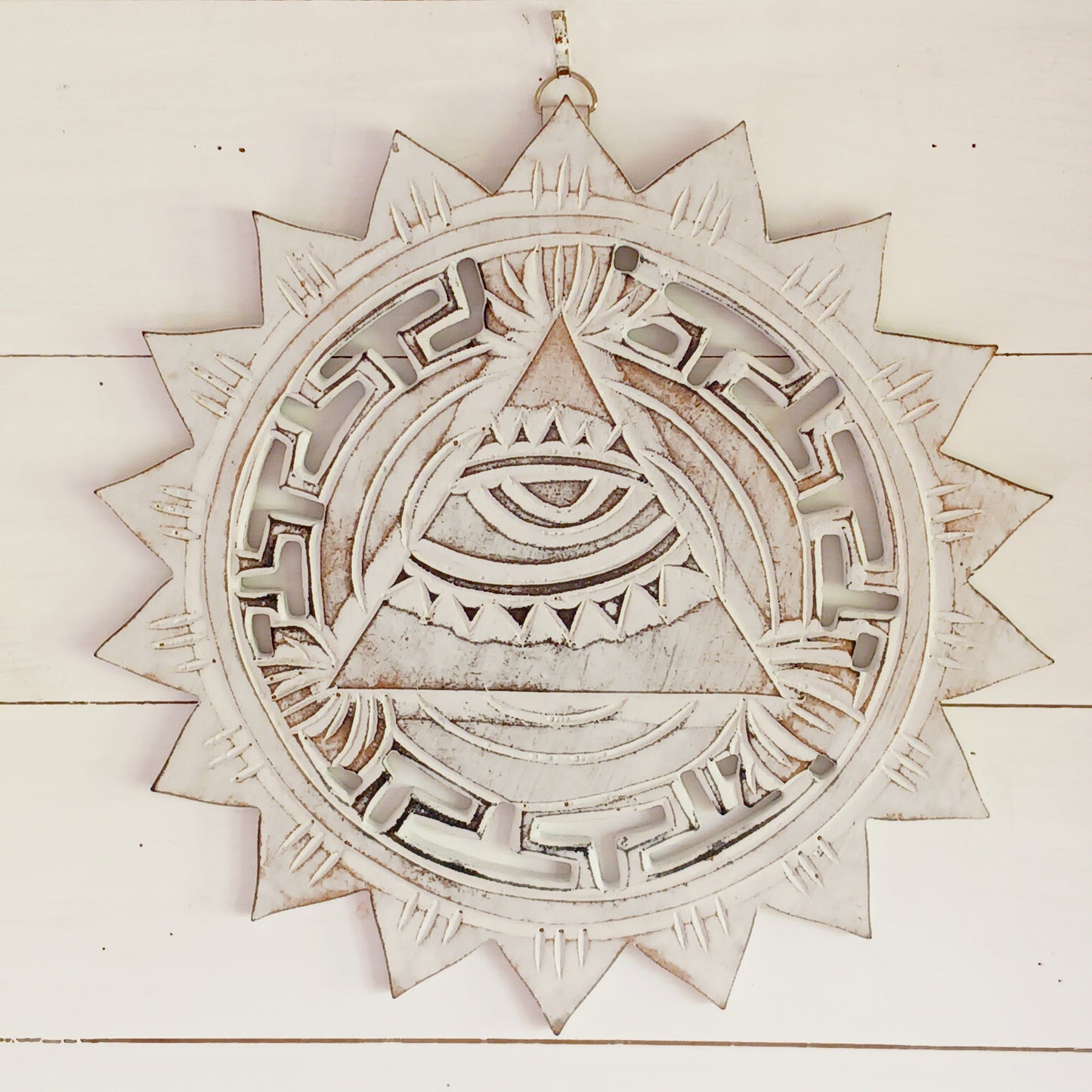 This wooden plaque has been intricately carved by hand to represent the Eye of Providence. The Eye of Providence or All-Seeing Eye is a symbol depicting an eye, often enclosed in a triangle and surrounded by a ray of light or a halo, intended to represent Providence, as the eye watches over the workers of mankind. In Christianity it serves as a reminder that humanitiy's thoughts and deeds are always obserbed by God.