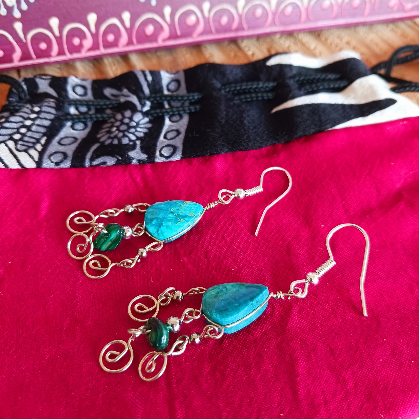 These beautiful spiral earrings feature a turquoise stone and three spirals. They dangle really nicely when worn, and are easy to dress up or down. The hooks are made from sterling silver.
