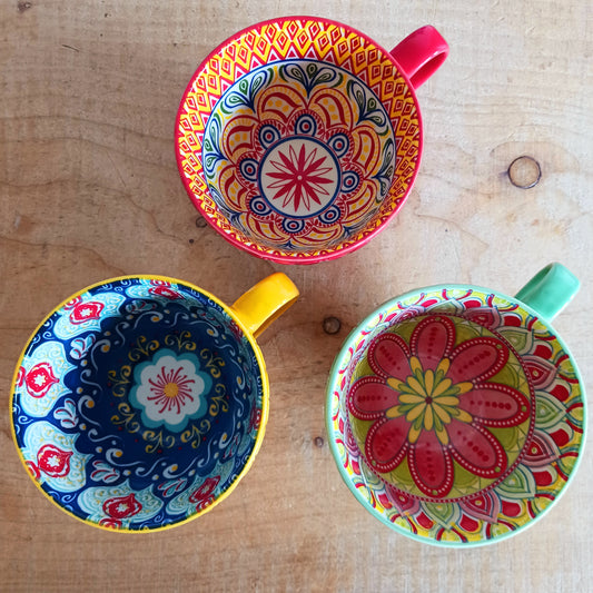 Bring Mediterranean charm to your kitchen with these beautiful Tuscany-inspired ceramic mugs. Featuring a vibrant glaze outside and embossed geometric patterns inside, they capture the rustic warmth of terracotta tiles and intricate murals found in sun-soaked Italian villages. The kaleidoscopic interiors add a burst of artistic flair, making them perfect for your morning coffee or evening tea. Stylish and versatile, these mugs are a thoughtful gift or a delightful treat for yourself.