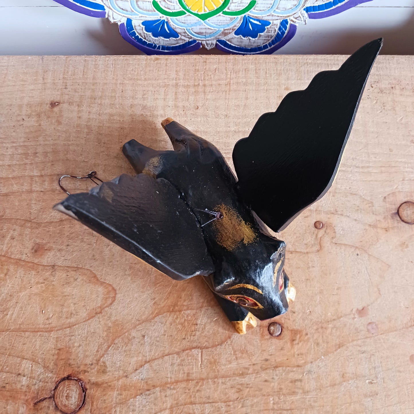 Invite protective energy and traditional charm into your home with this handcrafted Flying Pig Spirit Guardian from Bali. Known locally as a "Cradle Guardian," this winged figure is believed to ward off negative entities and is often placed in temples or homes, suspended from elevated areas like doorways or windows. Its downward-facing posture channels protection, while the strong twine loop allows for easy hanging.