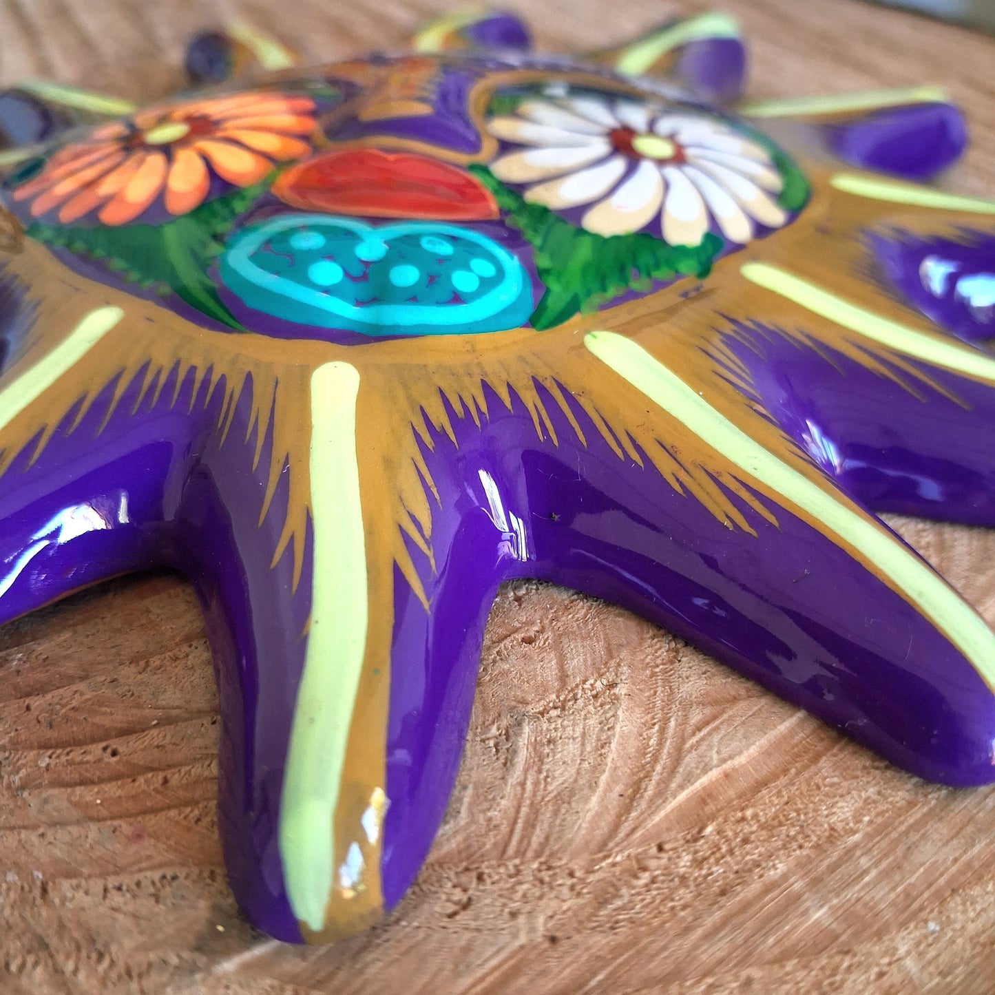 This sunny and vibrant wall plaque will get you smiling! It has been beautifully hand painted in a bright style traditional to Xalitla, a region of Guerrero, Mexico. A striking glaze adds to the bold design. It has two holes which can be used to add a hanging loop for an easy display.