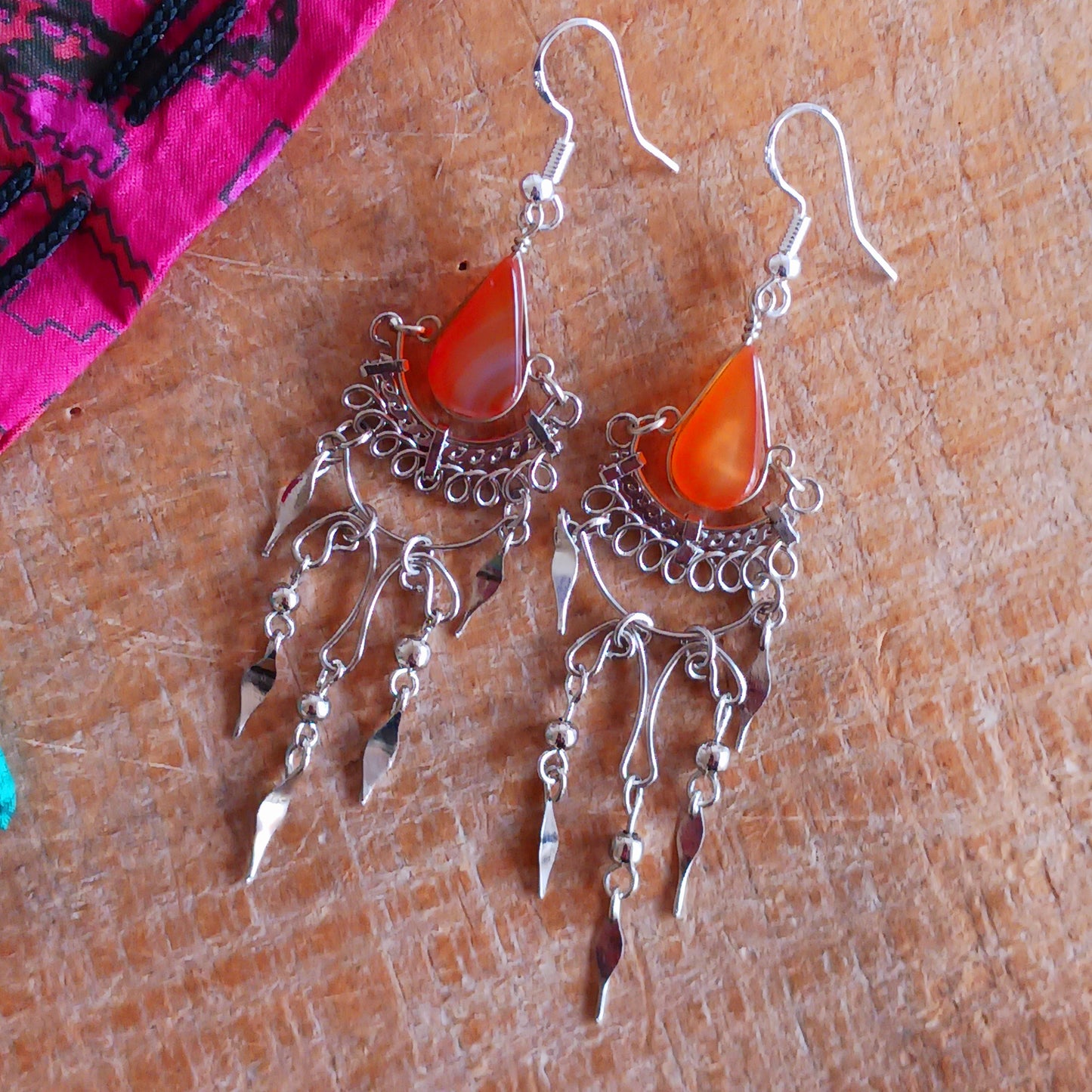 Add a touch of bohemian beauty to your look with these handmade Peruvian stone earrings. Featuring orange stones and finished with silver-plated hooks, each pair is carefully crafted in small workshops in Peru.