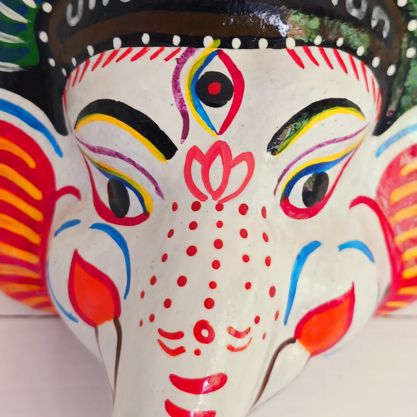 Bring the blessings of Ganesh into your home with this handcrafted terracotta mask from Nepal. Known as the remover of obstacles and the deity of wisdom, learning, and new beginnings, Ganesh is one of the most beloved figures in Hindu tradition. His elephant head and gentle features are beautifully captured in this spiritual wall hanging.