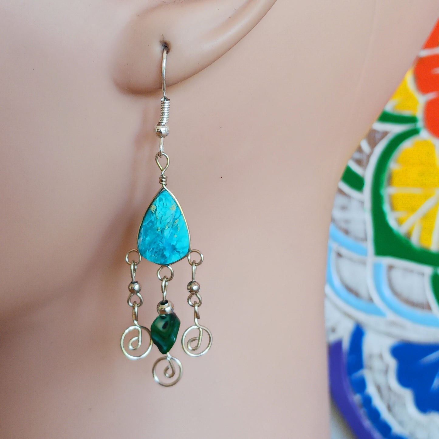 These beautiful spiral earrings feature a turquoise stone and three spirals. They dangle really nicely when worn, and are easy to dress up or down. The hooks are made from sterling silver.
