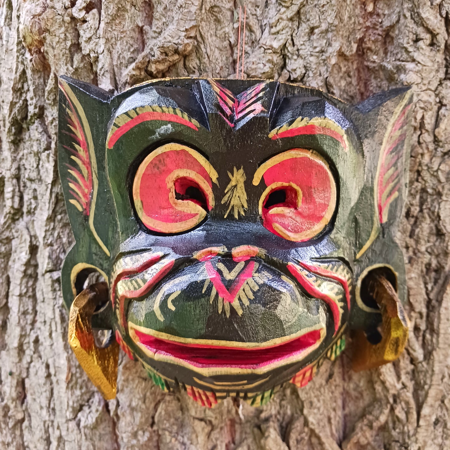 This hand carved and hand painted mask depicts Hanuman, the monkey god. He is integral to the Hindu tale of Ramayana, aiding Rama in the heroic rescue of his wife Sita.